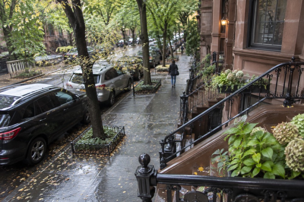 A brownstone stoop on a quiet tree-lined street in the West Village