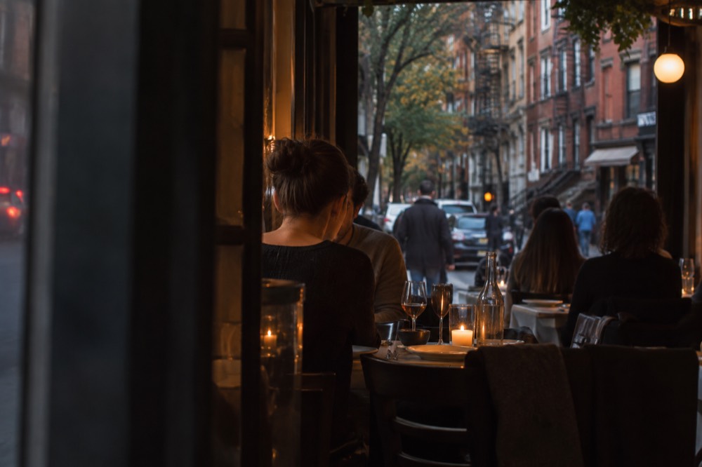 A candlelit Italian restaurant table in Greenwich Village at dinner time