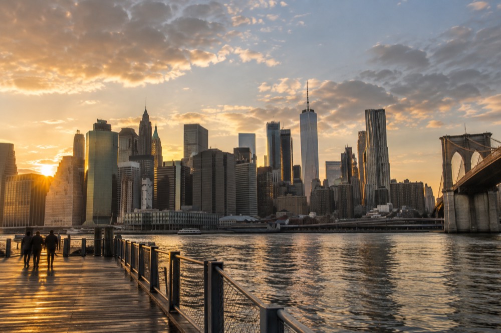 Golden evening light on the Manhattan skyline seen from a Brooklyn Bridge Park pier in Dumbo
