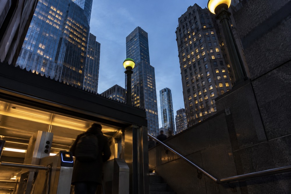 A subway entrance on a Financial District sidewalk with an OMNY reader at the turnstile