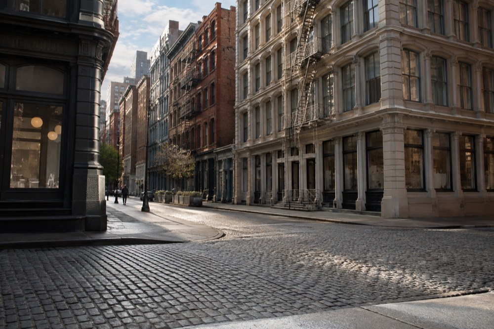 Wide empty cobblestone corner in SoHo in early morning light