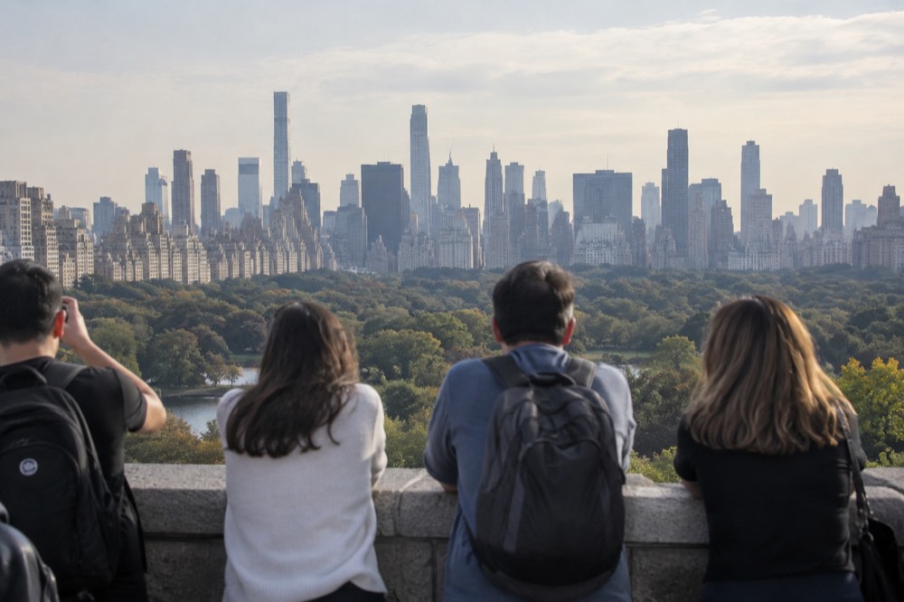 Visitors on an outdoor observation deck looking out over Central Park and the skyline