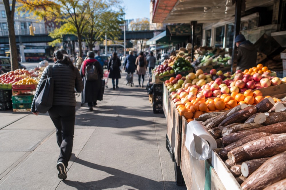 Street market stalls with produce and snacks in Jackson Heights, Queens