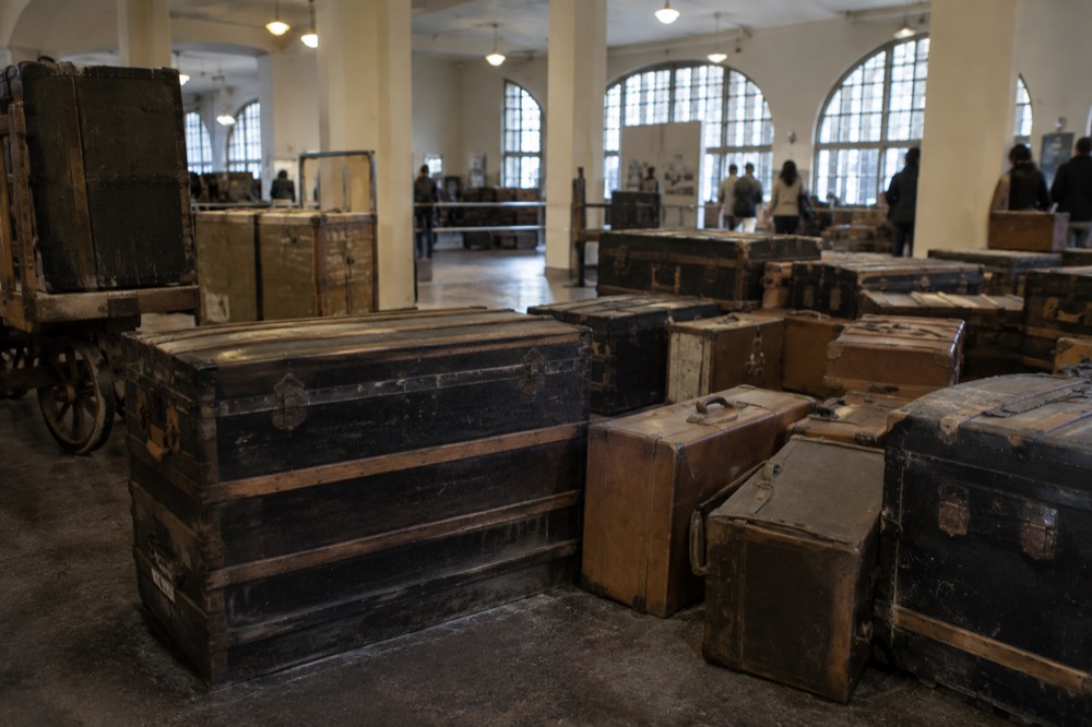 Restored baggage room at Ellis Island with wooden trunks and period suitcases arranged on the floor