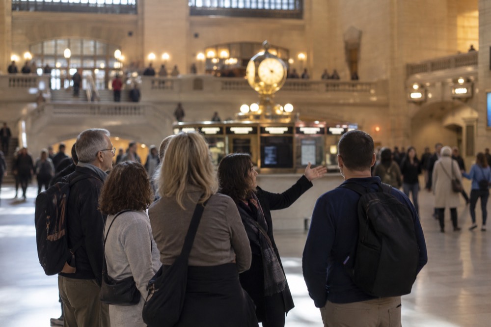A tour guide speaking to a small group in the main concourse of Grand Central Terminal