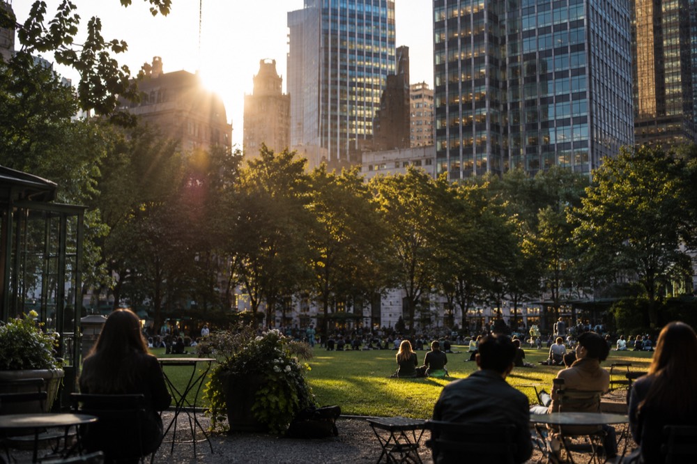 Trees and green lawn of Bryant Park with Midtown office towers rising behind them
