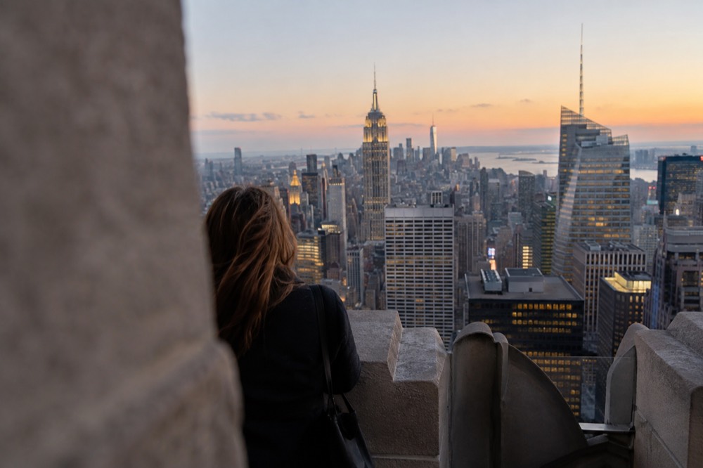 The skyscrapers of Midtown Manhattan rising above the rooftops around Rockefeller Center at dusk