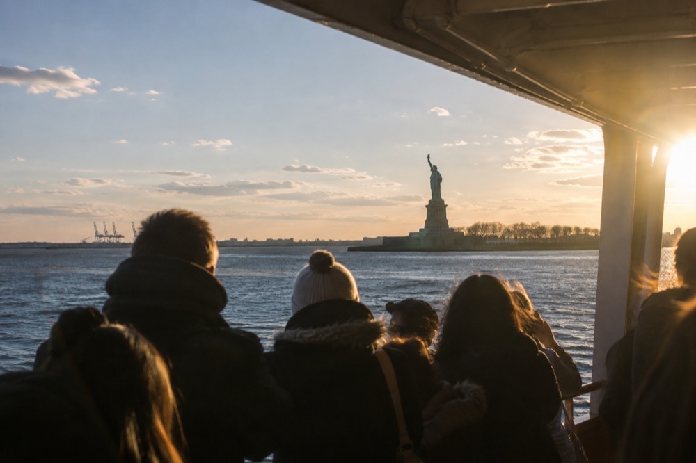 The Statue of Liberty seen across the water from the deck of a passing ferry