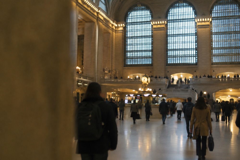 The main concourse of Grand Central Terminal with travelers crossing beneath the celestial ceiling and a departure board