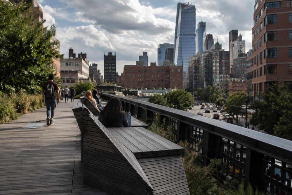 Wooden lounge seating on the High Line overlooking 10th Avenue traffic below