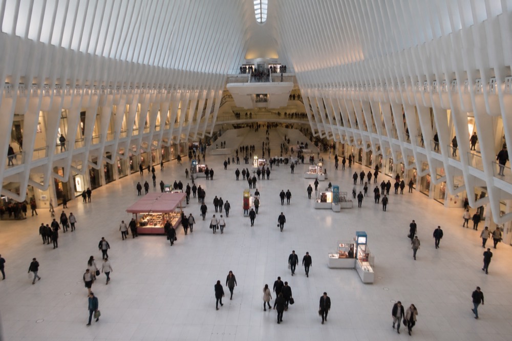 Shoppers and visitors walking through the retail concourse inside The Oculus