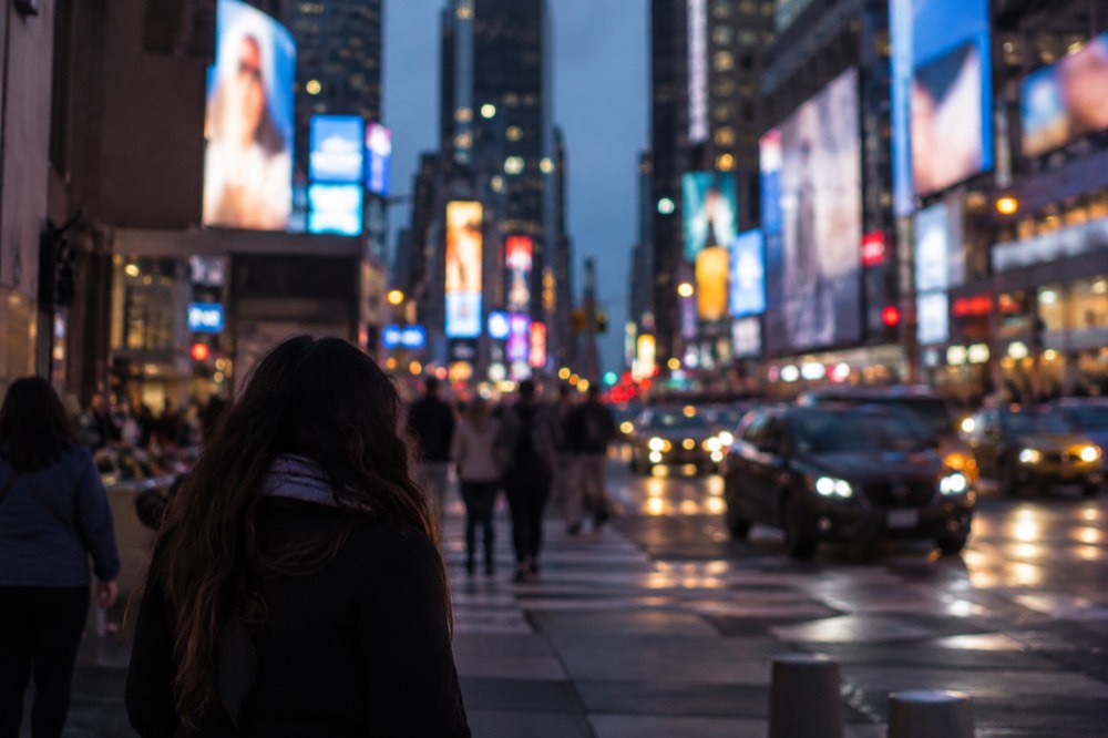 Times Square at night with billboards lighting the crowd below