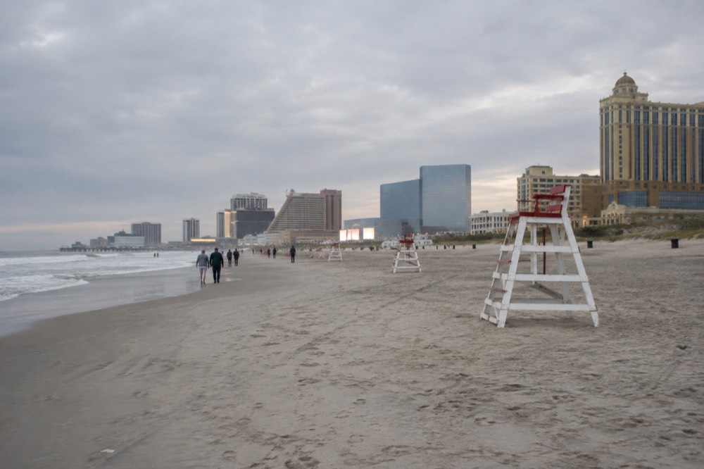 A wide sandy beach with lifeguard chairs and the Boardwalk hotels visible behind the dunes