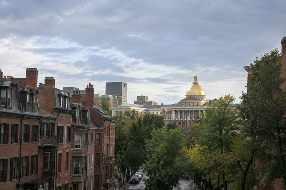 The Massachusetts State House golden dome rising above Beacon Hill rooftops