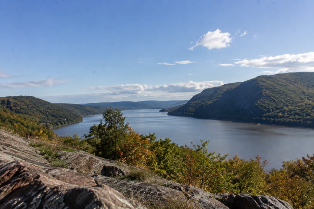 A wide river valley with forested ridges on both banks under a clear sky