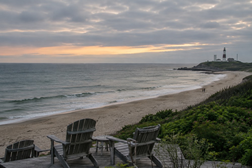 Empty summer beach chairs overlooking a calm Atlantic horizon in soft evening light