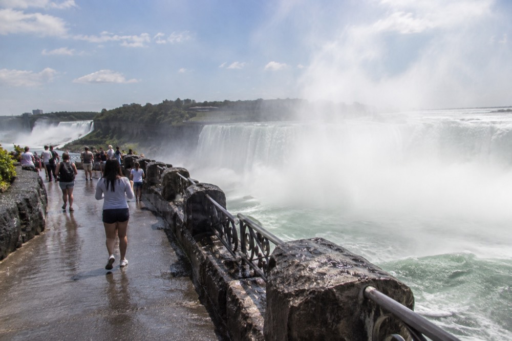 Water pouring over the wide curve of Horseshoe Falls with mist filling the air