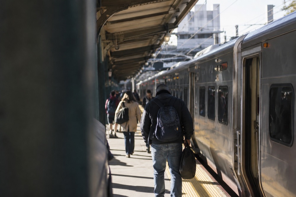 A regional train waiting at a platform inside a busy Northeast rail station