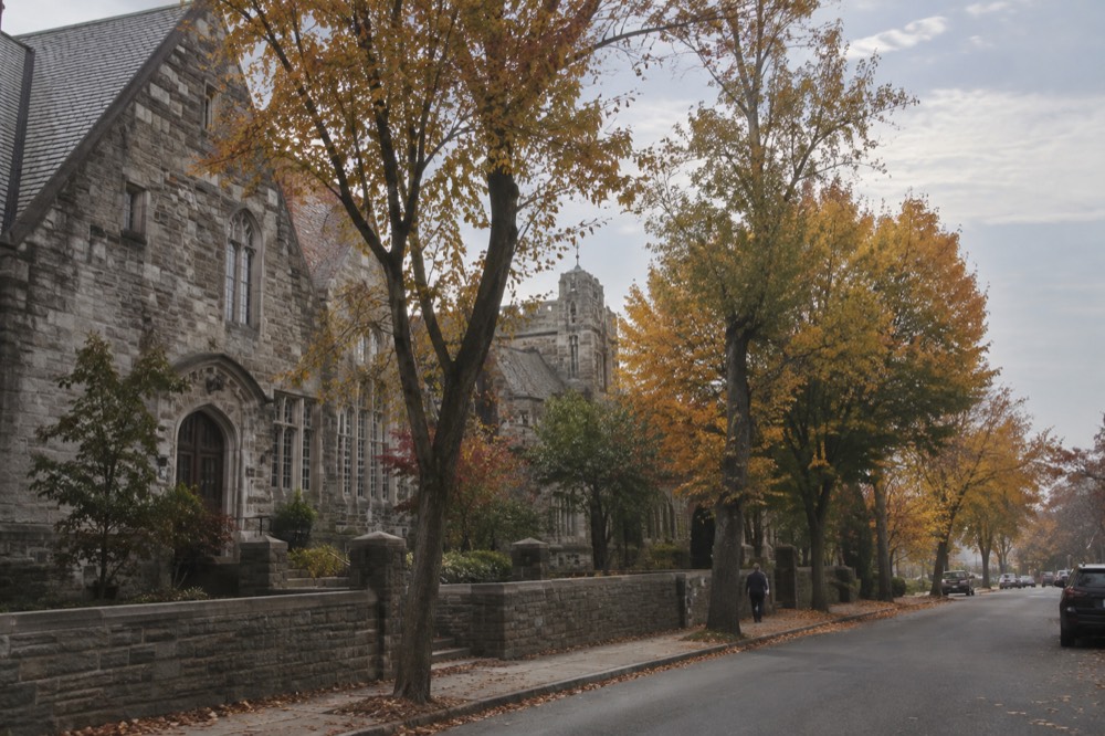 Autumn trees along a quiet street in Sleepy Hollow, New York, with historic stone buildings in the background