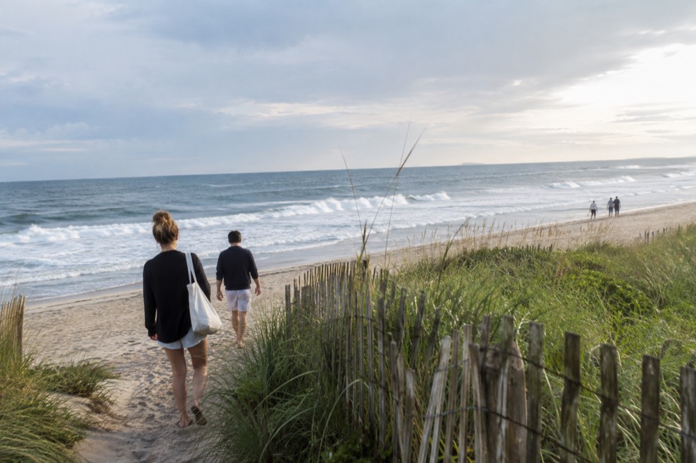 A wide Atlantic beach with rolling surf and low dune grass at the eastern end of Long Island