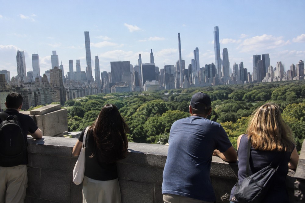 Visitors on an observation deck looking out over Central Park and the Midtown skyline