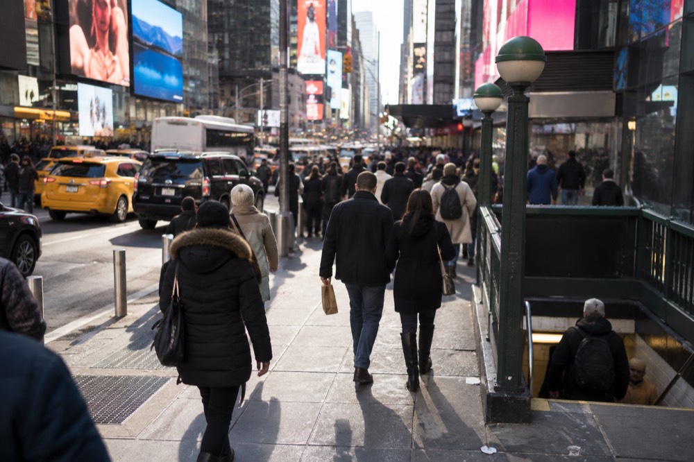 Theater District sidewalks at night with crowds heading toward glowing show marquees