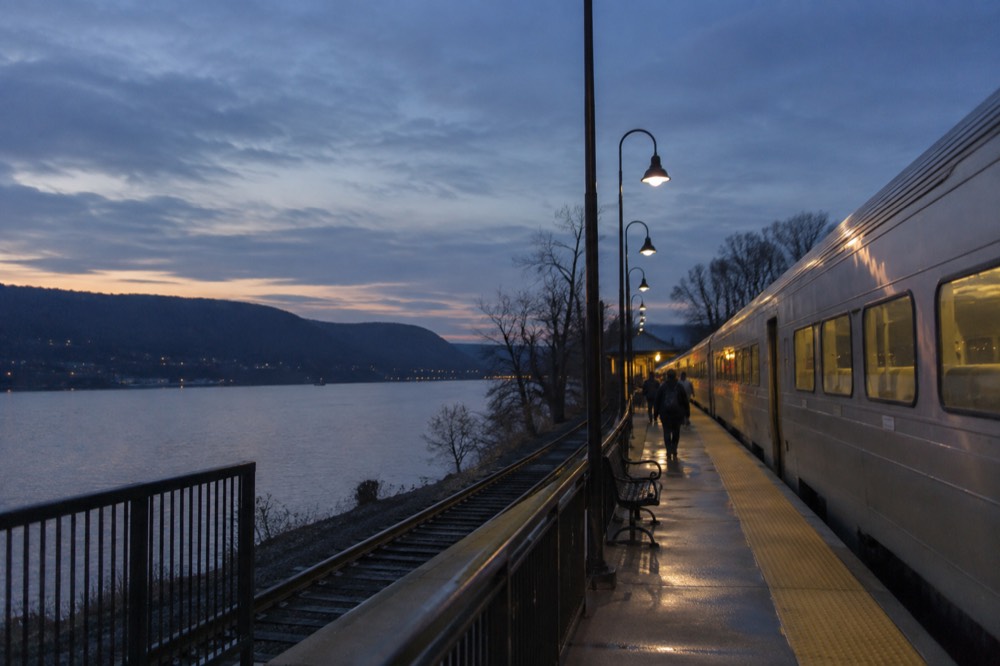 A Metro-North commuter train at a Hudson Valley station beside the river