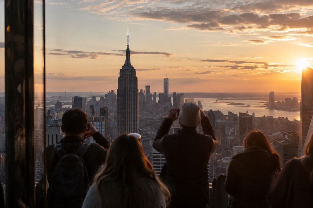 Observation deck visitors photographing the Manhattan skyline at sunset
