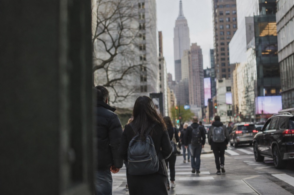 Travelers walking with a city map along a busy New York sidewalk