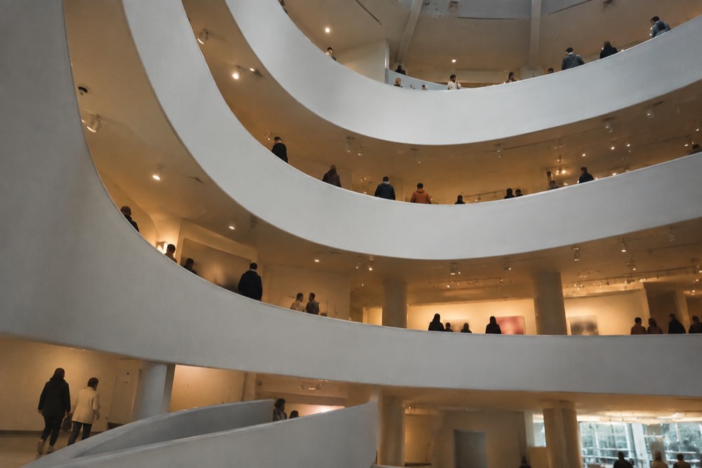 A spiral museum ramp seen from below with visitors on the walkway