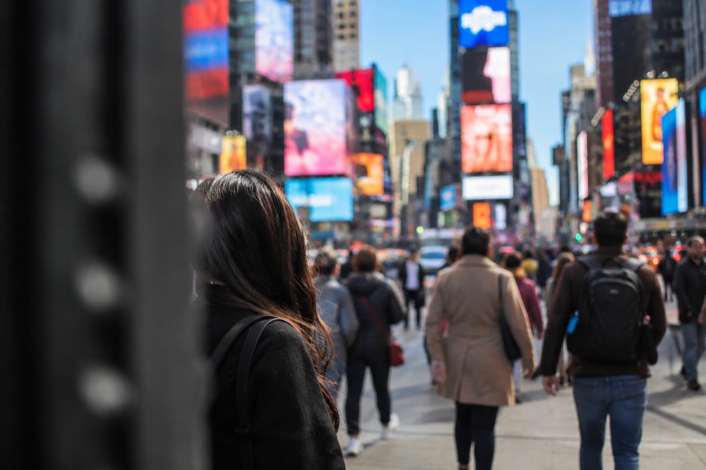 Times Square glowing with billboards and theater crowds on a warm evening in New York
