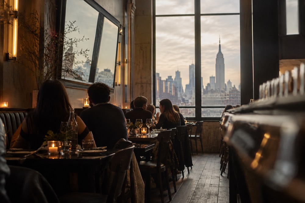 Diners seated at a candlelit table in a Manhattan restaurant