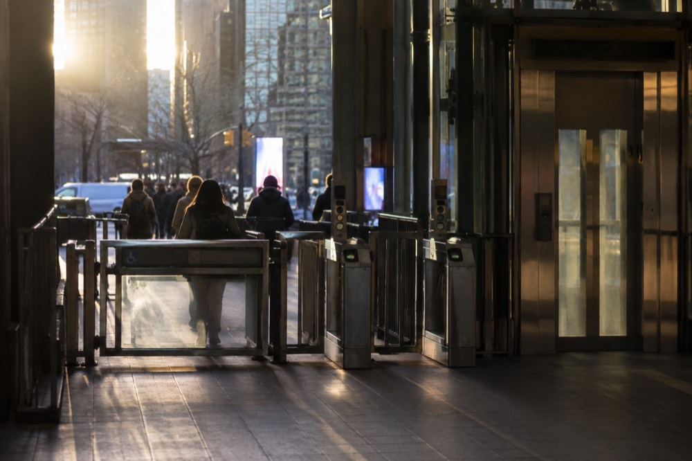 A subway station elevator and wide fare gate next to the turnstiles
