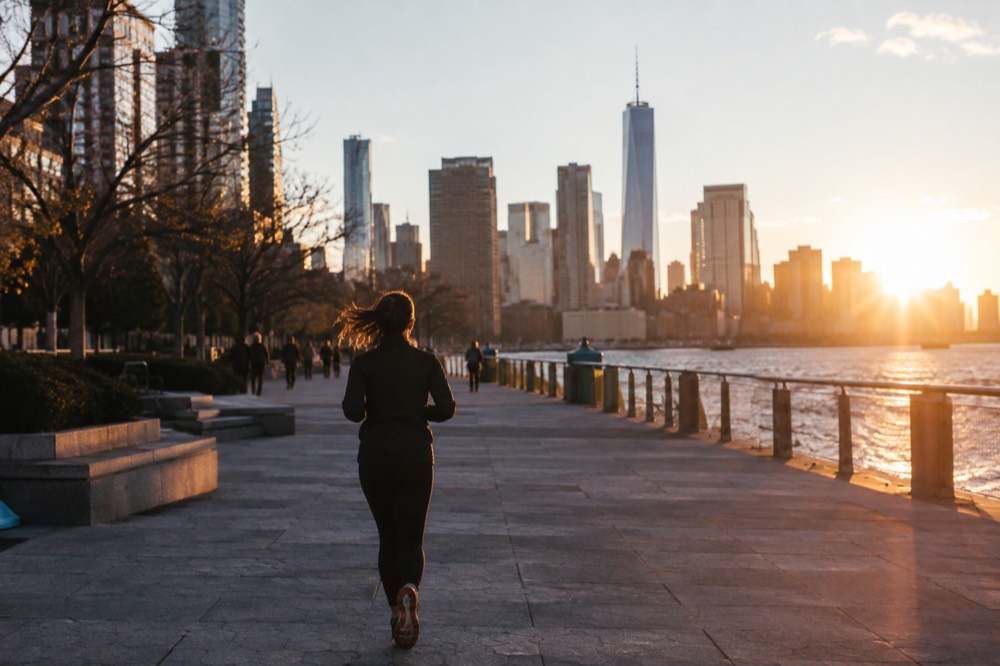 A wide, level pedestrian plaza in Lower Manhattan with a clear accessible path toward the skyline