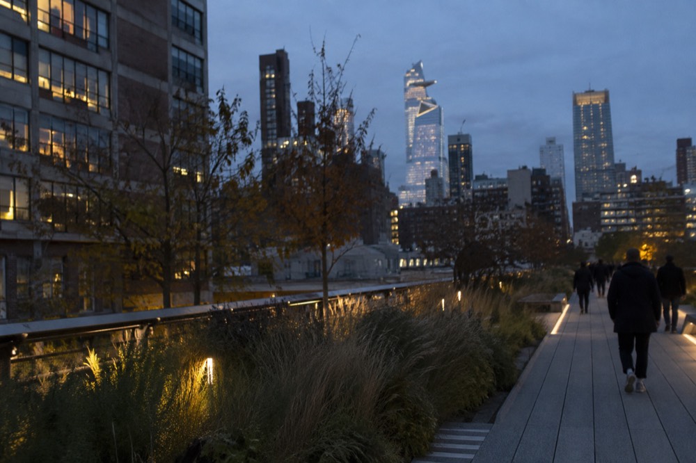 The High Line elevated walkway with level paths, plantings and the Manhattan skyline behind