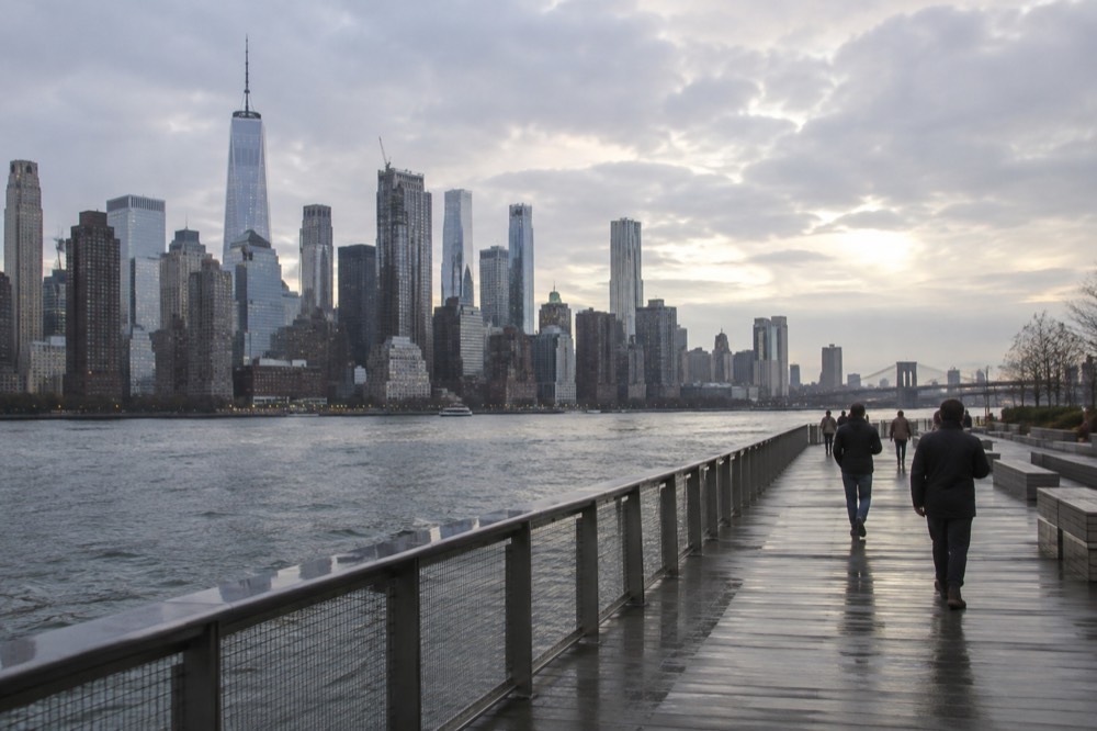 An accessible boardwalk path along the Manhattan waterfront with the skyline across the water