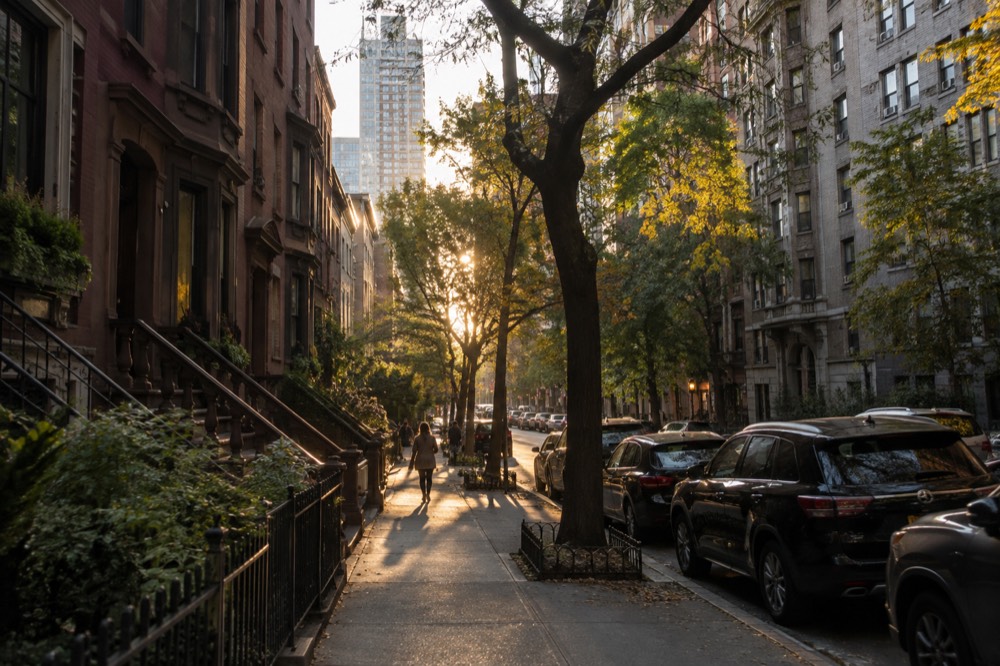 A quiet Murray Hill side street with brownstones and a high-rise beyond